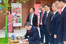 El profesor y doctor Le Van Loi, presidente de la Academia de Ciencias Sociales de Vietnam, plasma sus deseos de Año Nuevo en el espacio expositivo dedicado al árbol Neu, símbolo tradicional del pueblo vietnamita que representa un año nuevo de paz y bienestar.