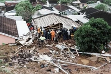 Búsqueda de víctimas atrapadas bajo una casa derrumbada tras las inundaciones en la ciudad de Durban, provincia de KwaZulu-Natal, Sudáfrica, el 12 de abril de 2022. (Foto: AFP/VNA)