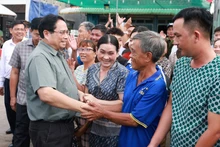 El primer ministro Pham Minh Chinh visita a los habitantes de la comuna de Binh My, provincia de An Giang. (Foto: VNA)