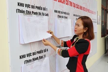 Los pobladores de la etnia Raglai en la comuna de Bac Ai Tay (Khanh Hoa) consultan la lista de votantes publicada oficialmente en la sede del Comité Popular comunal. (Foto: VNA)