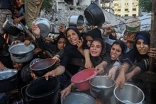 Palestinos desplazados esperan alimentos en un centro de distribución en la ciudad de Gaza, el 14 de julio de 2025. (Foto: Xinhua)