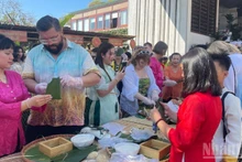 Turistas participan en el concurso de elaboración de “banh chung”.