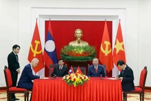 El secretario general del PCV, To Lam, y el secretario general del PPRL y presidente de Laos, Thongloun Sisoulith, presencian la firma de documentos de cooperación entre los dos países (Foto: VNA)