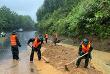 Guardias fronterizos de la ciudad de Hue excavan tierra y rocas para nivelar la carretera afectada por el deslizamiento de tierra en el paso de Pe Ke, en la comuna de A Luoi 1. (Foto: VNA)