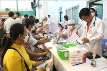 El personal médico realizan chequeos a las personas que participan en el programa. (Foto: VNA)