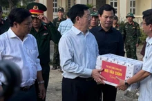 El viceprimer ministro Mai Van Chinh (izquierda) visita la comuna de Xuan Canh para brindar apoyo y entregar obsequios a los residentes afectados por el tifón Kalmaegi (Foto: Nhan Dan)