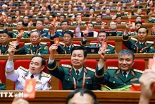 Los delegados votan para aprobar la Resolución del XIV Congreso Nacional del Partido. (Foto: VNA)