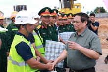 El primer ministro Pham Minh Chinh (derecha) se reúne con las unidades encargadas de la construcción de la terminal T2 del Aeropuerto Dong Hoi (Foto: VNA)