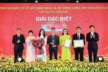 Nguyen Duy Ngoc, secretario del Comité del PCV en Hanói, y Hoang Trung Dung, subjefe permanente de la Comisión de Organización del Comité Central del Partido, entregan el Premio Especial a autores del periódico Hanoimoi.