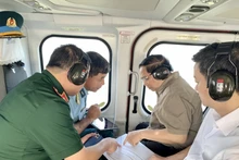 El primer ministro Pham Minh Chinh (segundo desde la derecha) realiza una inspección aérea desde un helicóptero de la autopista Ca Mau-Dat Mui, la carretera que conduce a Hon Khoai y el puerto de doble uso de Hon Khoai. (Foto: VNA)