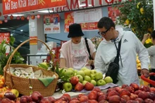 Extranjeros compran frutas en un mercado vietnamita. (Fuente: VNA)