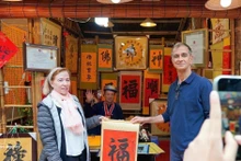 Los turistas internacionales disfrutan de la tradición de recibir caligrafía auspiciosa a principios de año. (Foto: VNA)