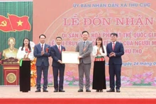 Un representante del Ministerio de Cultura, Deportes y Turismo entrega el certificado que reconoce al Festival Tet Doi como Patrimonio Cultural Inmaterial Nacional.