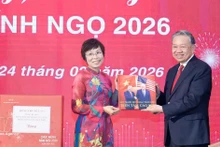 La directora general de la VNA, Vu Viet Trang, obsequia al secretario general To Lam un libro fotográfico realizado por reporteros de la agencia. (Foto: VNA)