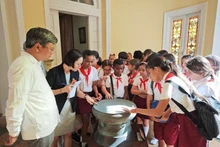 Alumnos habaneros curiosos por un prototipo del Tambor de bronce, símbolo de la cultura vietnamita. (Fotografía: Embajada de Vietnam en Cuba)