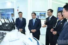 El primer ministro Pham Minh Chinh visita la sala memorial y de productos tecnológicos del Grupo VNPT. (Foto: Nhan Dan)