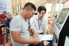 Funcionarios guiando a ciudadanos en la realización de trámites administrativos en la provincia de Quang Ngai. (Foto: VNA)