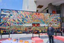 El pintor Chu Nhat Quang y su obra “Tío Ho lee la Declaración de Independencia”. (Foto: Nhan Dan)