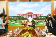 El teniente general Hoang Xuan Chien, viceministro de Defensa de Vietnam, entrega un certificado de reconocimiento a Aler Grubbs por sus destacadas contribuciones a la remediación del Agente Naranja/dioxina en Vietnam. (Fotografía: VNA)