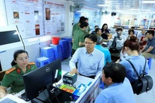 Funcionarios del Departamento de Inmigración enseñan a los extranjeros el proceso de otorgamiento de cuentas de identificación electrónica de nivel 2. (Fotografía: sggp.org.vn)