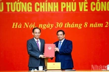 El primer ministro Pham Minh Chinh entrega la decisión de nombramiento al miembro del Secretariado del Comité Central del Partido Comunista de Vietnam y jefe de su Oficina, Le Hoai Trung. (Foto: VNA)