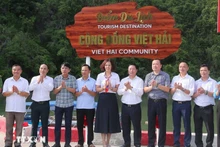 Los delegados realizan la ceremonia de colocación del cartel del Sitio de Turismo Comunitario de Viet Hai. (Foto: VNA)