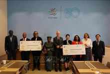 El ministro consejero Pham Quang Huy (primero a la derecha) y el comité organizador del Concurso Campeones de las Pequeñas Empresas 2025. (Fotografía: VNA)