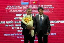 El presidente de la VSFA, Lam Dung Tien, entrega flores al cónsul general de Singapur en Ciudad Ho Chi Minh, Pang Te Cheng, en la reunión. (Foto: sggp.org.vn)
