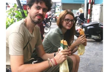 Visitantes internacionales se deleitan con la comida callejera de Hanói. (Foto: VNA)