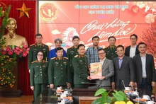 Le Quoc Minh, presidente-editor de Nhan Dan, entrega publicaciones del Tet de Nhan Dan a oficiales y soldados del Departamento de Propaganda y Educación, del Departamento General de Política del Ejército Popular de Vietnam.