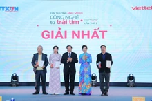 La directora general de la VNA y presidenta del Consejo del Premio, Vu Viet Trang, y el viceministro de Cultura, Deportes y Turismo, Ta Quang Dong, entregan el primer premio a los autores. (Foto: VNA)