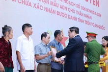 El primer ministro Pham Minh Chinh entrega la notificación de los resultados del examen de ADN a los familiares de los mártires. (Foto: VNA)