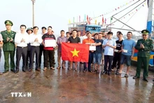El vicepresidente del Comité Popular Provincial de Quang Tri, Le Van Bao (fila superior, cuarto desde la derecha), entrega regalos y recuerda a los pescadores el estricto cumplimiento de las normas contra la pesca INDNR. (Foto: VNA)