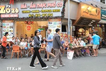 Turistas extranjeros disfrutan de la gastronomía en la calle Ta Hien, Hanói. (Foto: VNA)