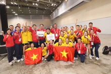 Las jugadoras y el cuerpo técnico de la selección femenina vietnamita de balonmano celebran su medalla de oro. (Foto: VNA)