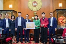 El presidente-editor del periódico Nhan Dan, Le Quoc Minh, entrega la asistencia a las víctimas de las inundaciones.