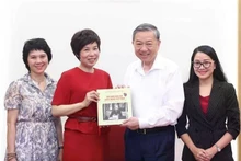 La directora general de la Agencia Vietnamita de Noticias (VNA), Vu Viet Trang, entrega al secretario general del Partido Comunista del país (PCV), To Lam, el libro de fotos bilingüe vietnamita-inglés “100 años de la Prensa Revolucionaria de Vietnam. (Foto: VNA)