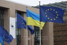 La bandera de la Unión Europea y la bandera de Ucrania en la sede de la Comisión Europea en Bruselas, Bélgica. (Foto: Xinhua/TTXVN)