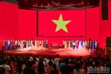 Artistas e invitados durante la ceremonia de saludo a la bandera nacional.
