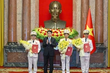 El presidente vietnamita, Luong Cuong, entrega las decisiones de ascenso al rango de coronel general a los tres viceministros de Seguridad Pública. (Foto: VNA)