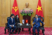 El director de la Academia Nacional de Política Ho Chi Minh, Doan Minh Huan (derecha), recibe al director general del Grupo Samsung Vietnam, Na Ki Hong. 