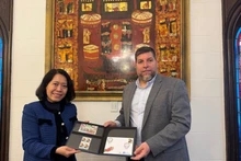 El diputado Víctor Aldaya entrega a la embajadora de Vietnam en Aregentina, Ngo Minh Nguyet, un juego de sellos emitidos por Correos del Uruguay en diciembre de 2013, en conmemoración del 20º aniversario de las relaciones diplomáticas entre Vietnam y Uruguay, con el retrato del General Vo Nguyen Giap. (Foto: VNA)
