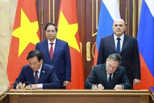 El primer ministro vietnamita, Pham Minh Chinh (de pie, a la izquierda), y su homólogo ruso, Mikhail Mishustin (de pie, a la derecha), presencian la firma del acuerdo entre ambos gobiernos para la cooperación en la construcción de una central nuclear en el país indochino. (Foto: VNA)