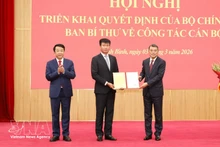 Le Minh Hung, miembro del Buró Político, secretario del Comité Central del Partido y jefe de su Comisión de Organización, entrega la decisión a Tran Huy Tuan. (Foto: VNA)