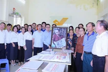 Le Quoc Minh, presidente-editor de Nhan Dan, entrega un cuadro del tío Ho leyendo el periódico Nhan Dan a los cuadros, miembros del Partido y habitantes de la comuna de Tan Hung en la oficina de correo y centro cultural de la comuna de Tan Hung.