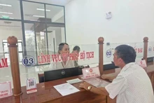 Las personas hacen trámites administrativos en el día del inicio de la prueba del gobierno de dos niveles en el distrito de Pleiku, Gia Lai. (Foto: VNA)