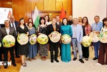 La embajadora de Vietnam en Bulgaria, Nguyen Thi Minh Nguyet, se toma una foto de recuerdo con periodistas búlgaros. (Foto: VNA)