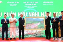 Representantes de la comuna de Huong Son ofrecen a la delegación una pintura del arroyo Yen en el conjunto paisajístico de Huong Son.