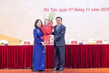 El miembro del Buró Político y permanente del Secretariado del Comité Central del Partido Comunista de Vietnam (PCV), Tran Cam Tu, entrega flores para felicitar a Bui Thi Minh Hoai, nueva presidenta del Frente de la Patria. (Foto: VNA)