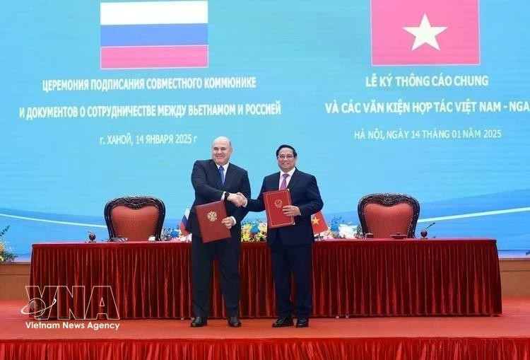 El primer ministro Pham Minh Chinh y su homólogo ruso, Mikhail Vladimirovich Mishustin, firman un comunicado conjunto sobre los resultados de la visita oficial a Vietnam del jefe del Gobierno de Rusia (Hanói, 14 de enero de 2025). (Foto: VNA)